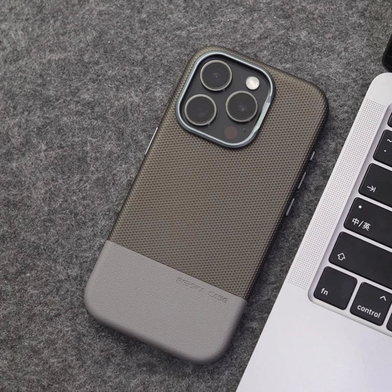 جراب هاتف iPhone 16 Pro Max جلد متباين بتصميم أنيق وحماية فائقة بجانب لابتوب.